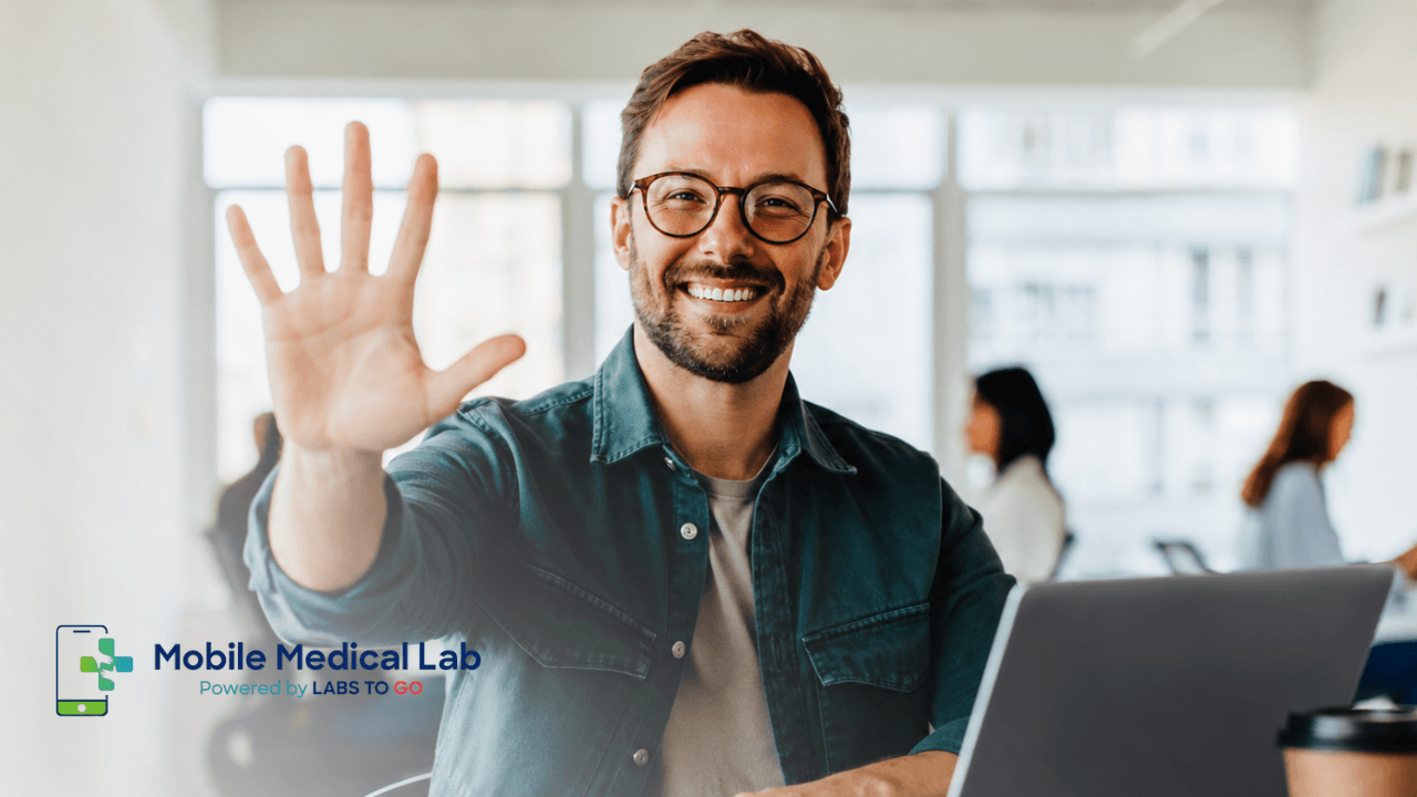 Smiling professional holding up five fingers at a laptop, representing five reasons professionals choose Mobile Medical Lab